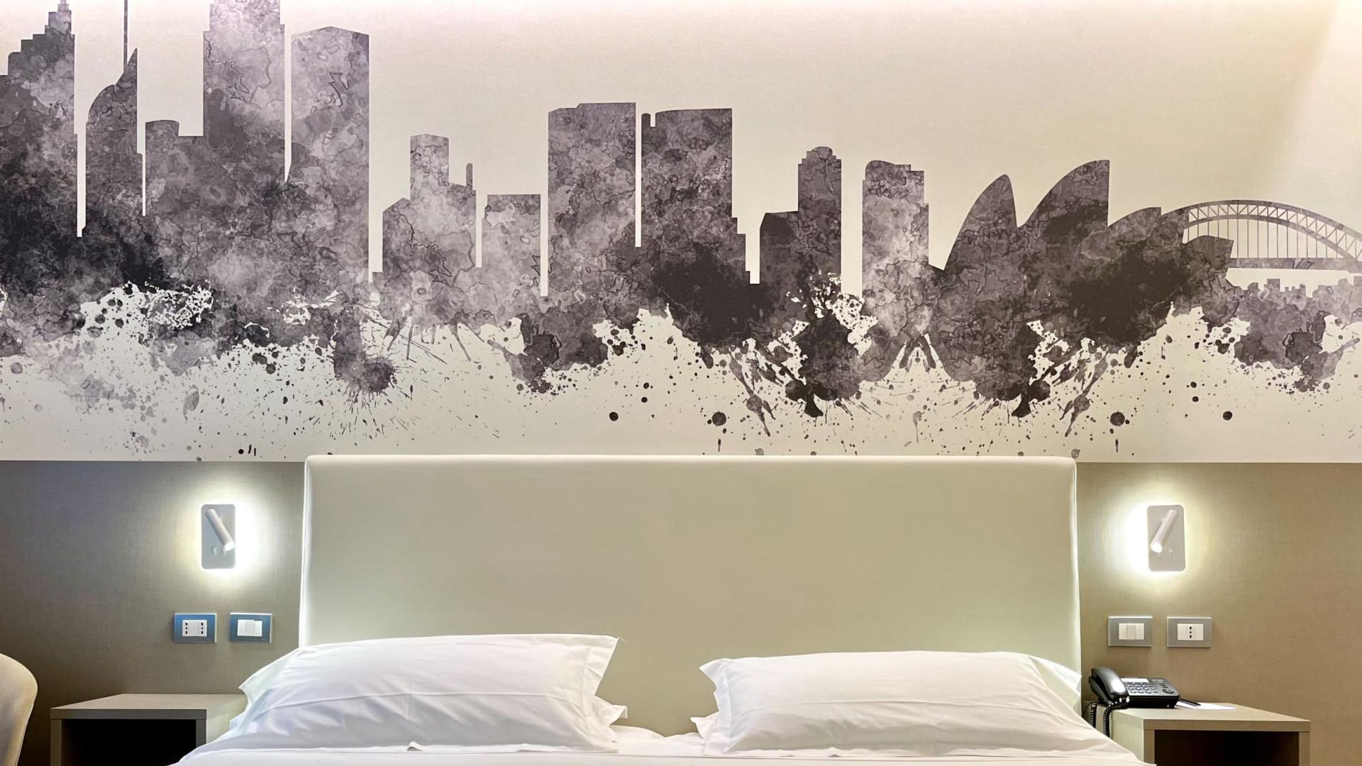 Bedroom with artistic skyline above the bed.