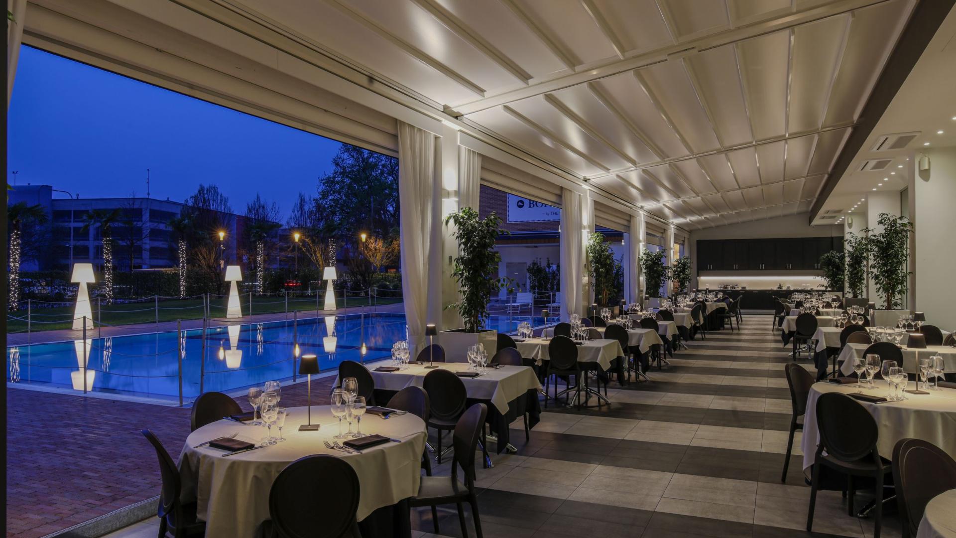 Elegant restaurant with pool view, cozy evening atmosphere.