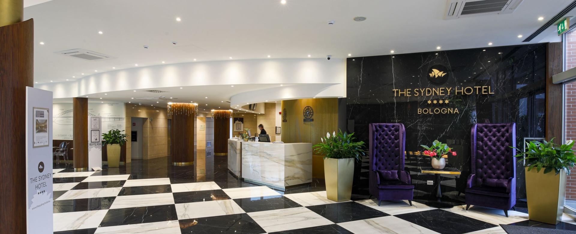 Elegant hotel lobby with checkered floor and modern furnishings.